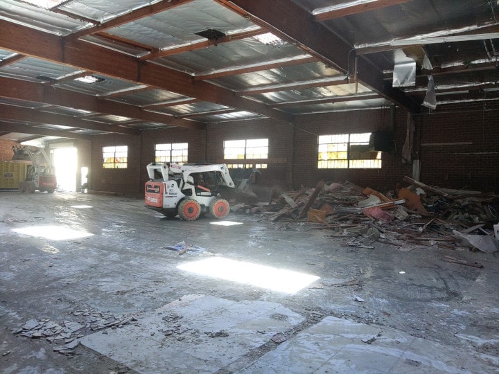 bobcat removing demolition debris - far away view
