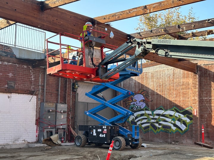 crane lifting worker inside demolition site
