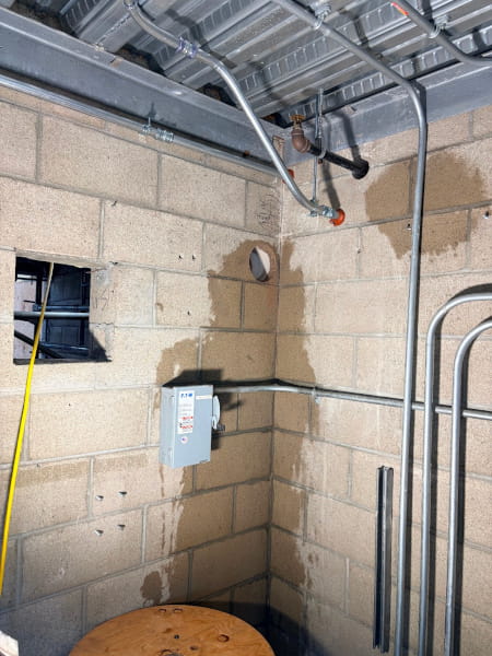 Circular core drilled hole in the back concrete wall of an elevator shaft